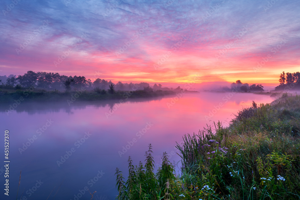 Colorful sunrise over the river banks