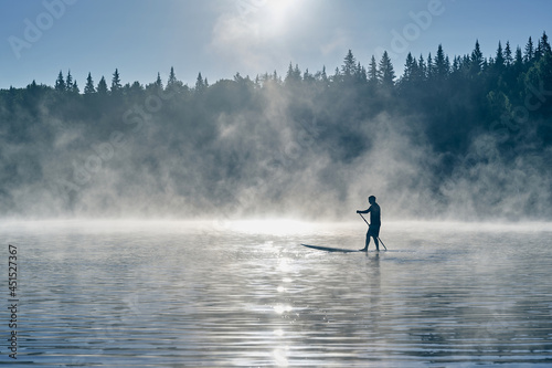 Photography Man paddling on a surf board in fog