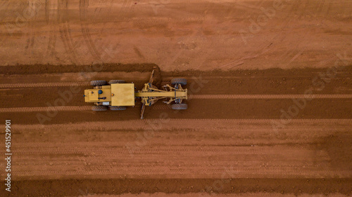 Fotografie Aerial view yellow excavator building a highway, Road grader heavy earth moving, Bulldozer working at road construction