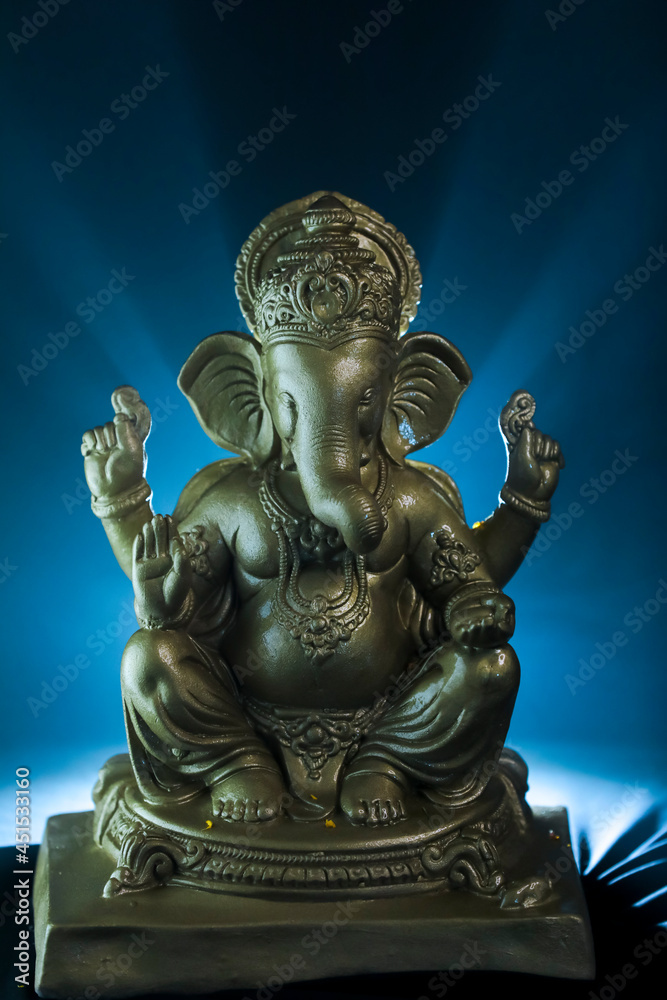 Golden lord ganesha sclupture over dark background. celebrate lord ganesha festival.