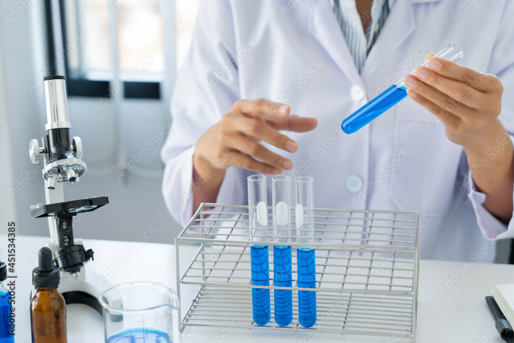 scientists researching in laboratory in white lab coat, gloves analysing, looking at test tubes sample, biotechnology concept scientists researching in laboratory in white lab coat, gloves analysing, looking at test tubes sample, biotechnology concept