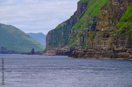 Beautiful rock cliff coast line of Faroe Islands with breathtaking landscape nature scenery, popular cruise travel destination in Atlantic Ocean near Polar Circle for expedition tours photo