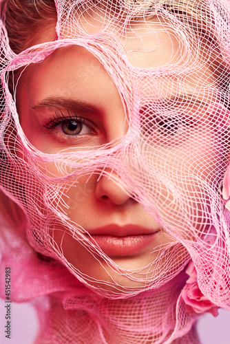 Fototapeta Naklejka Na Ścianę i Meble -  Macro portrait of woman in pink netting fabric