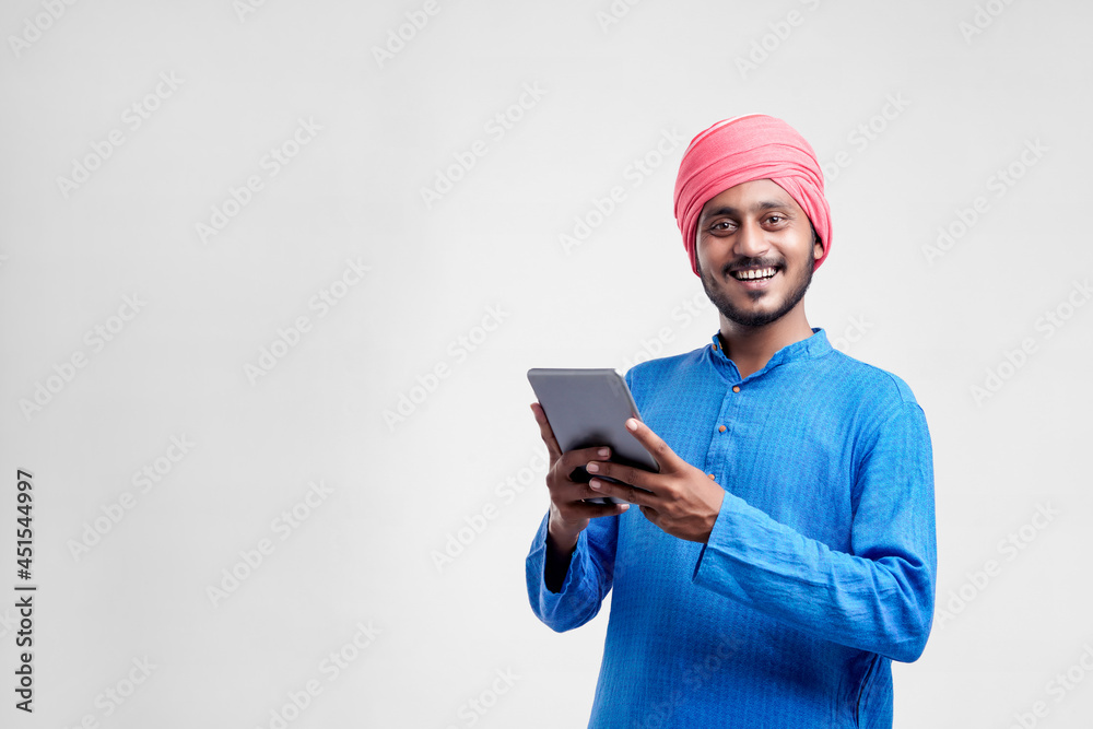 Young indian farmer using tablet and giving expression on white background. Young indian farmer using tablet and giving expression on white background.