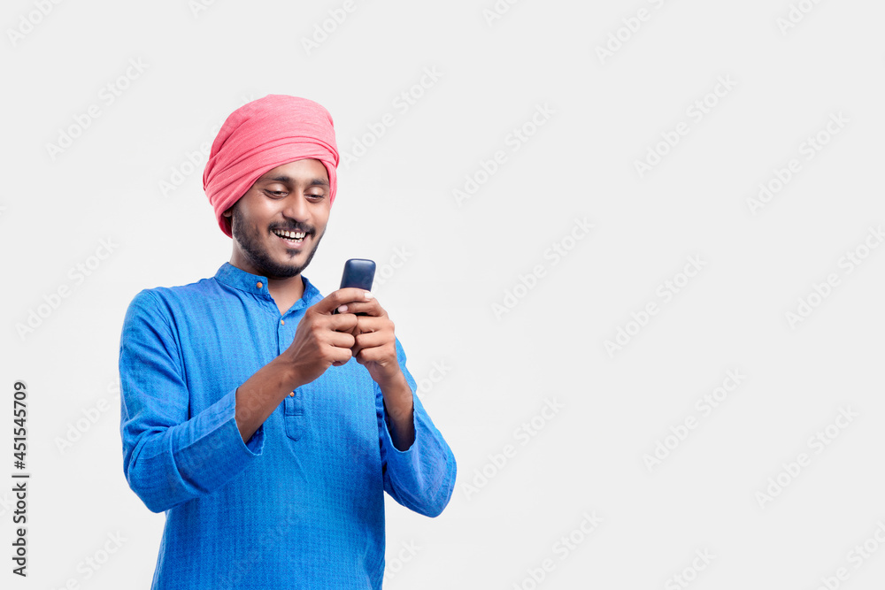 Young indian farmer using mobile phone over white background.