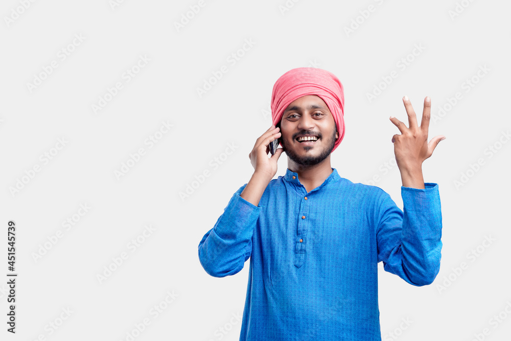 Young indian farmer talking on mobile phone over white background. Young indian farmer talking on mobile phone over white background.