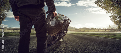 Motorradfahrer mit Motorrad auf einer Landstraße photo