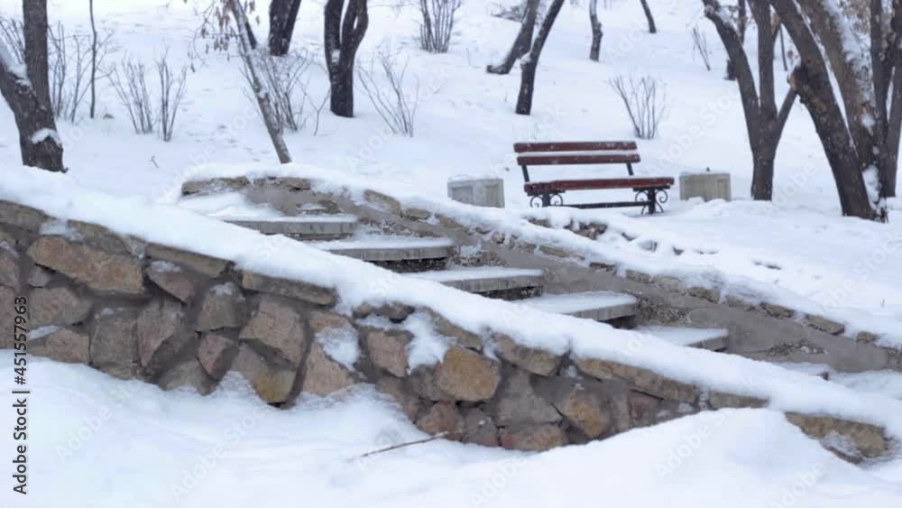 Snowfall in winter public park, masonry stairs under snow with snowdrifts in cold snowy season Snowfall in winter public park, masonry stairs under snow with snowdrifts in cold snowy season