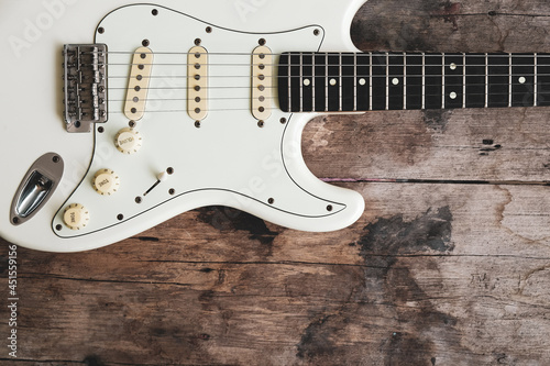 Photography Detail of White Electric Guitar on a wood background.