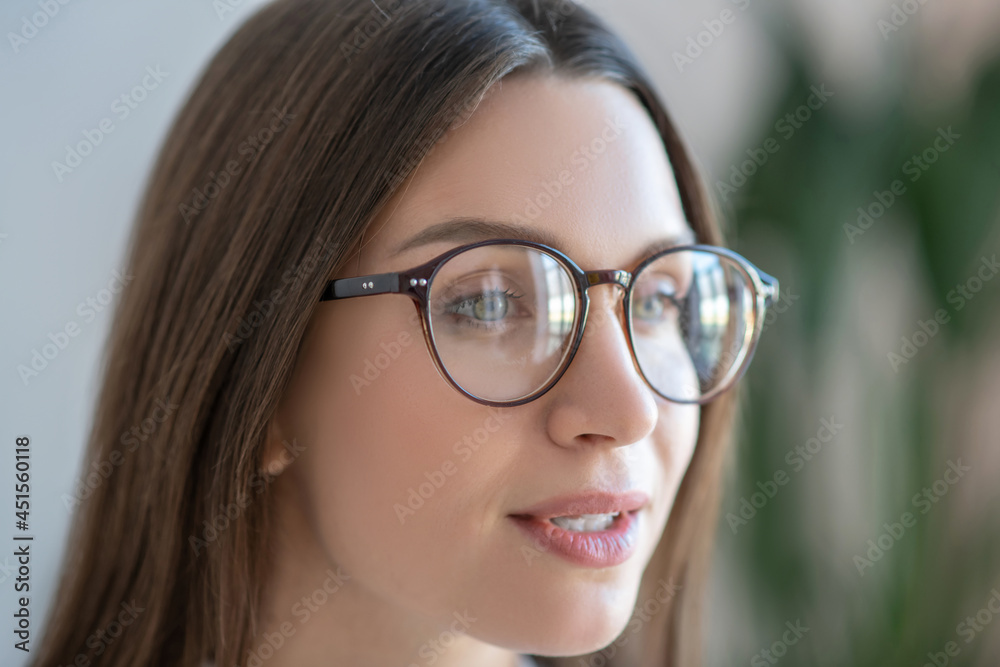 Headshot of long-haired woman in eyeglasses looking positive Headshot of long-haired woman in eyeglasses looking positive
