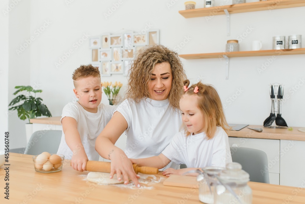 happy family in the kitchen. mother and children preparing the dough, bake cookies happy family in the kitchen. mother and children preparing the dough, bake cookies