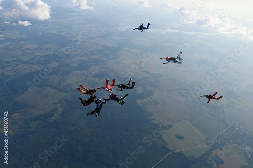 Skydiving.  A team of skydivers is in the sky.