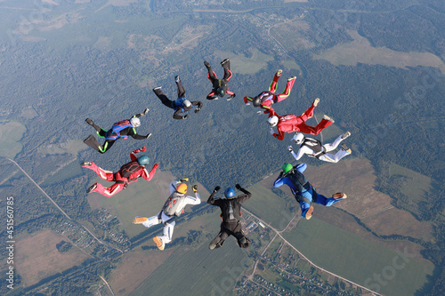 Skydiving.  A team of skydivers is in the sky.
