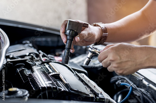Konstfotografi Close up spark plug coil in hand a man and use block wrench remove a bolt in ser