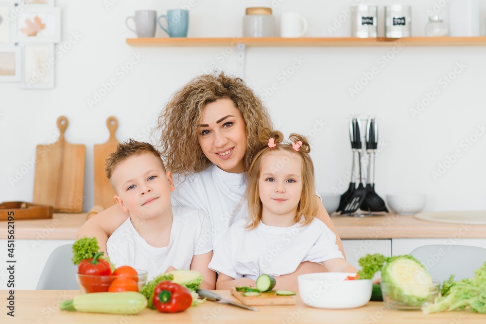 mother with children preparing vegetable salad at home mother with children preparing vegetable salad at home