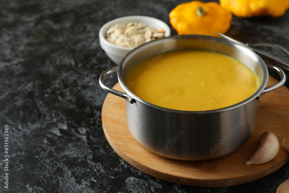 Concept of tasty food with pumpkin soup on black smokey table Concept of tasty food with pumpkin soup on black smokey table