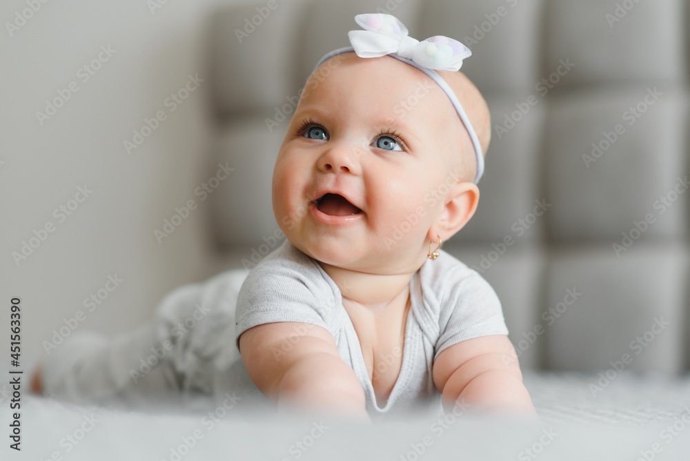 Cute happy 7 month baby girl in diaper lying and playing Cute happy 7 month baby girl in diaper lying and playing