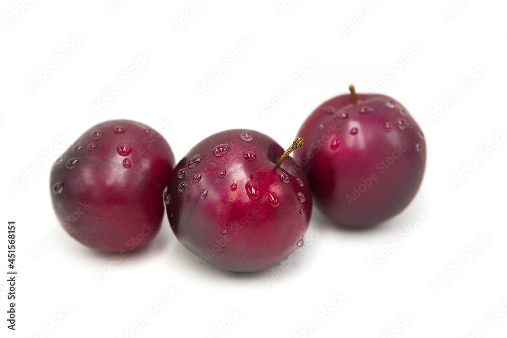 Ripe fresh organic plums in dew drops isolated on white background.