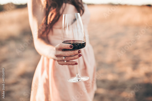 Young woman with glass of red wine during picnic