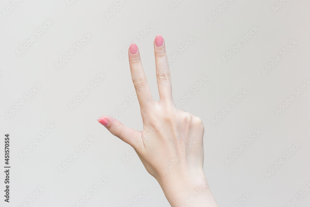 Woman’s hand shows up three fingers as number three on white background. Woman’s hand shows up three fingers as number three on white background.