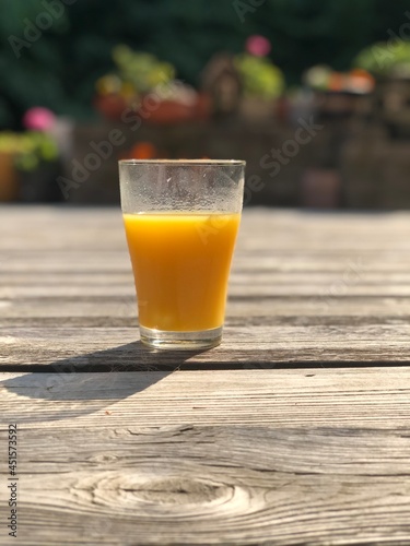 Photo of a glass of orange juice in summer