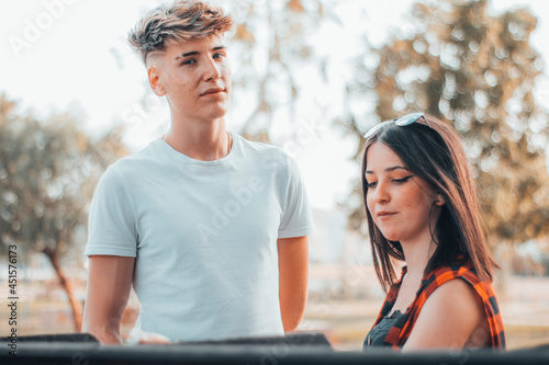 Canvas Print Chica joven cocinando unos pinchos en una parrilla con amigos en un parque al ai