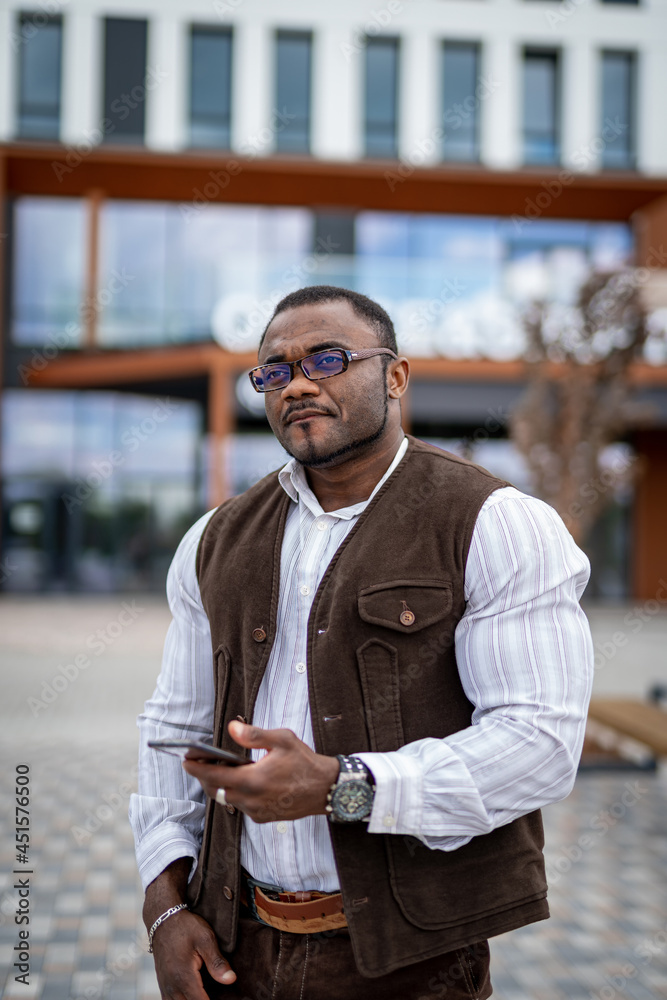 Obraz premium Handsome office manager preparing to speaking on mobile phone outdoor. Looking confident and preparing to important conversation. Serious man wearing stylish formal clothes