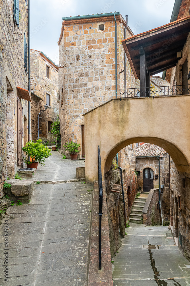 picturesque view of Sorano with old staircase, alley, underpass and plants in the Tuscan medieval village