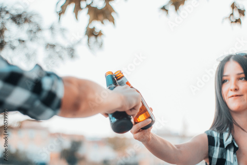 Muchacha en una fiesta de vacaciones de brindis en barbacoa reuniéndose para comer y beber cerveza en un parque haciendo un picnic