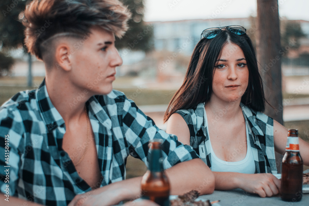 Obraz premium Pareja romantica de fiesta de vacaciones en barbacoa reuniéndose para comer y beber cerveza en un parque haciendo un picnic