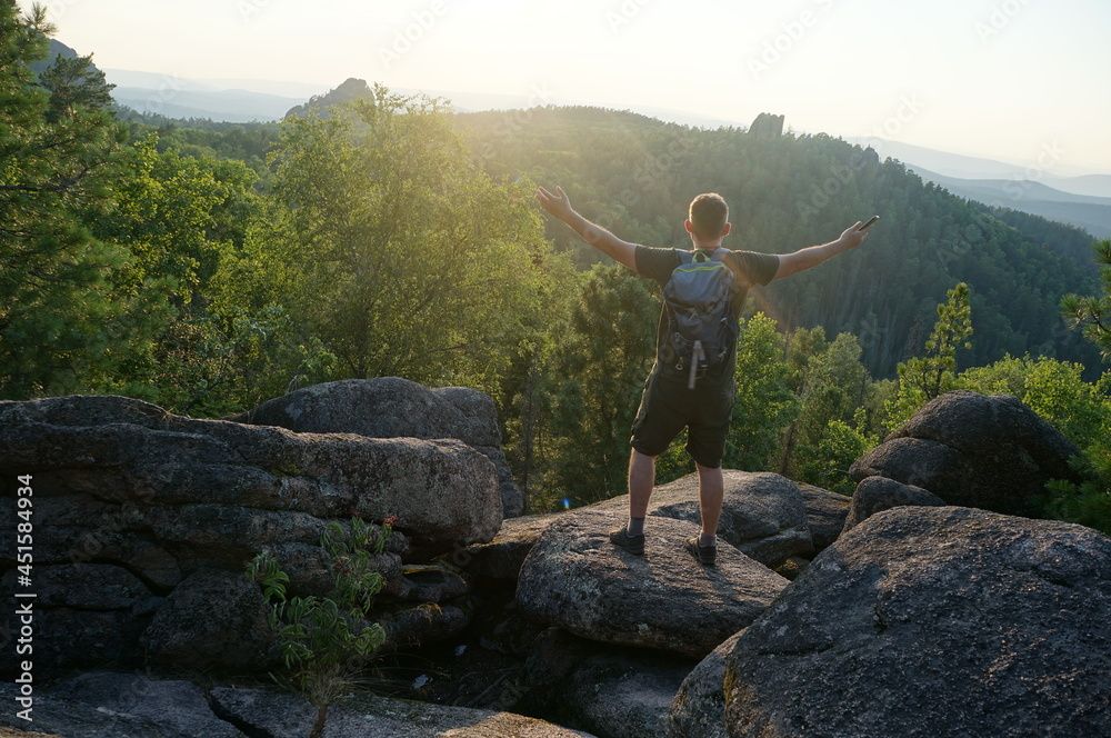 male hiker enjoying beautiful sunset in rocky mountains