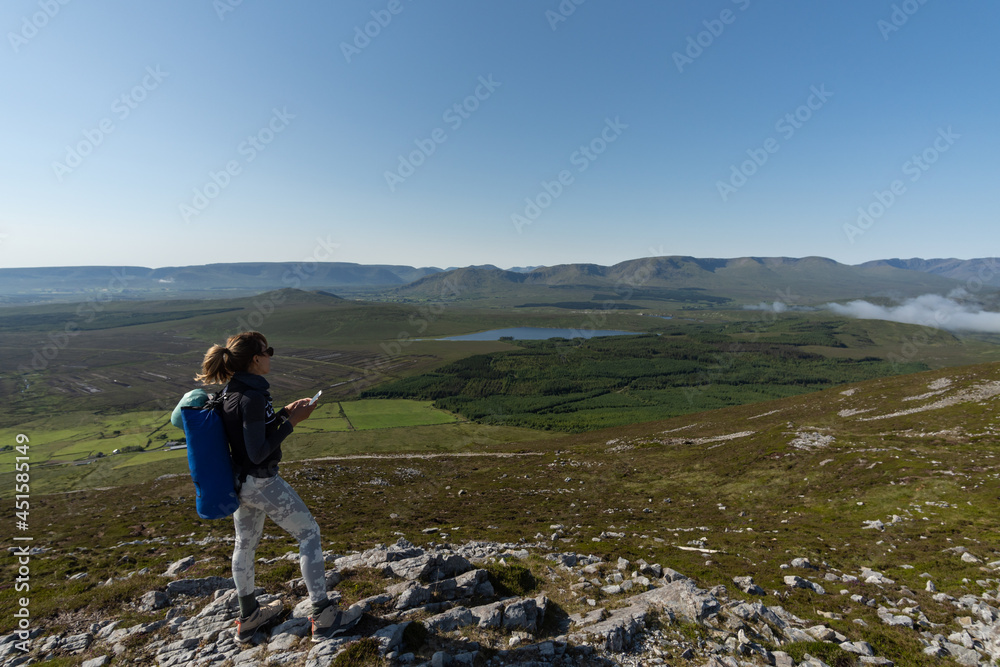 Young climber woman with her mobile phone in mountain