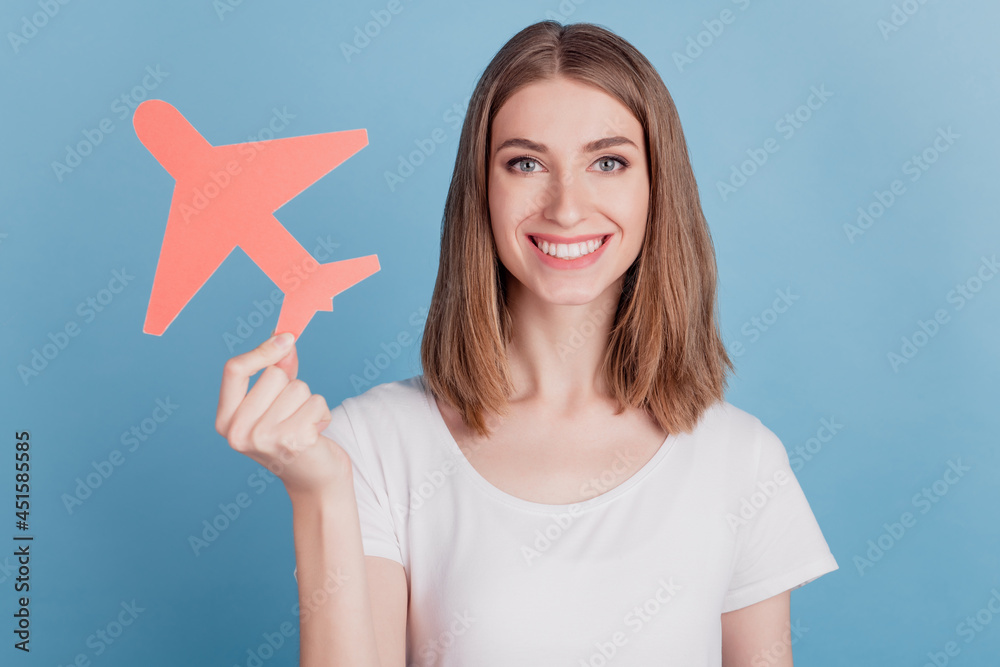 Portrait of reliable positive lady hold paper plane shiny white smile on blue background Portrait of reliable positive lady hold paper plane shiny white smile on blue background