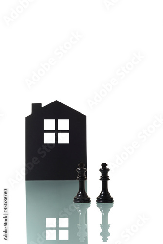 Chess pieces with silhouette of a house in the background. photo