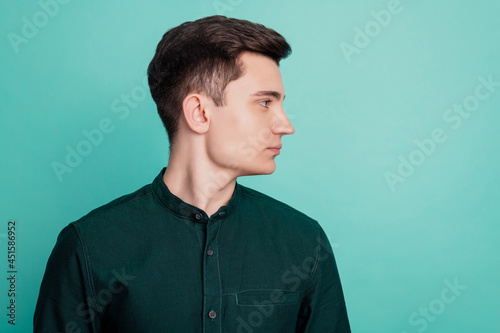 Portrait of serious businessman look over teal empty space teal background