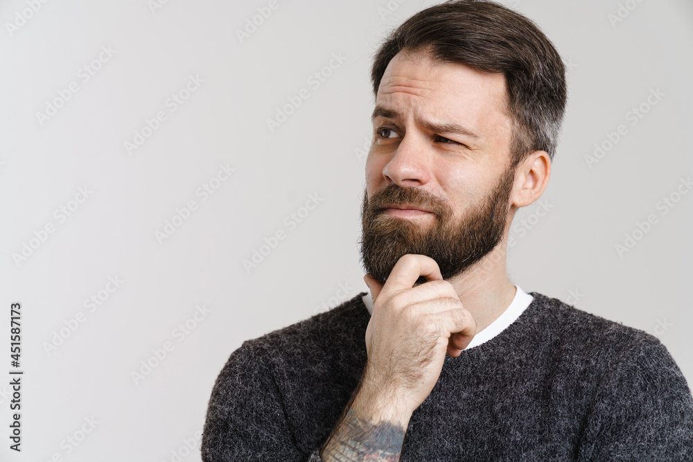 White puzzled man with beard posing and looking aside White puzzled man with beard posing and looking aside