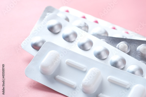 Fototapet Close up of pills of blister pack on pink background