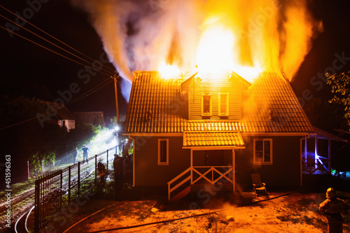 Wooden rural house is burning in fire at night