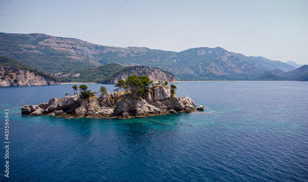 Katic island in Montenegro. A unique place with unique flora and fauna. Pines and green grass grow on the rocks of the island.