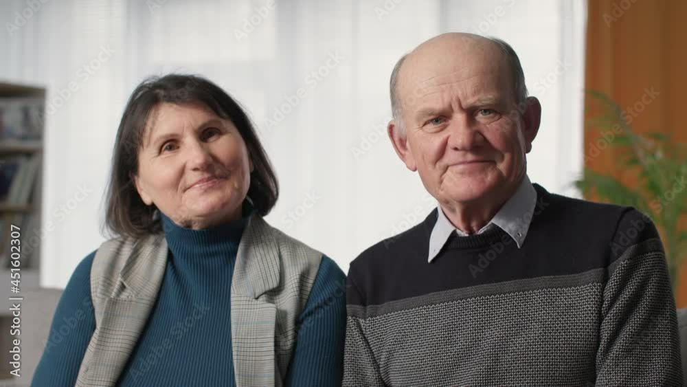 male and female retirees consult doctor online via webcam on laptop while sitting at home during pandemic due to coronavirus, looking at camera male and female retirees consult doctor online via webcam on laptop while sitting at home during pandemic due to coronavirus, looking at camera