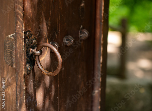 Obraz na plátně An old asian weathered wooden door with rusty iron ring.