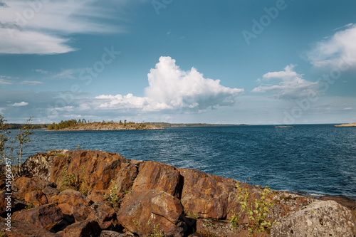 Landscape. A harsh rocky shore. View of the island. Beautiful low clouds