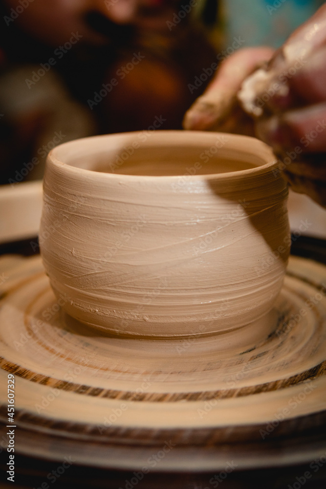 Potter working on potters wheel with clay. Process of making ceramic tableware in pottery workshop. Handicraft and art concept. Potter working on potters wheel with clay. Process of making ceramic tableware in pottery workshop. Handicraft and art concept.