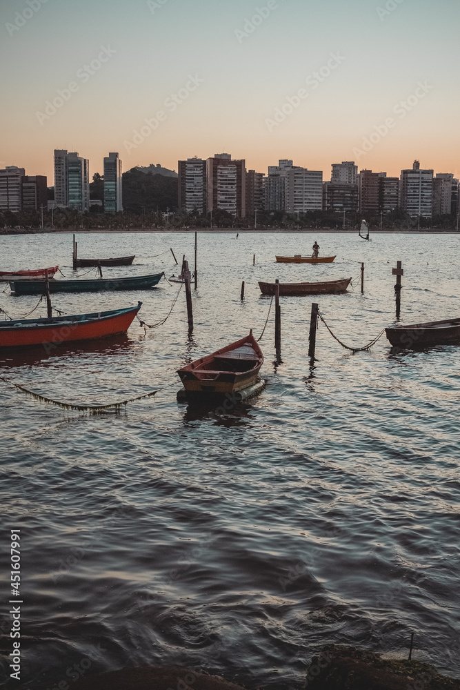 Boats moored on a beautiful sunset day in calm waters in the bay of Vitória, Brazil.