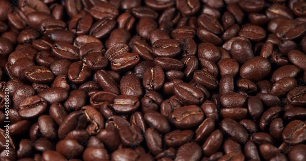 Roasted coffee beans dolly shot. Aromatic coffee beans move slowly. Slide slow motion close-up of whole roasted coffee beans. Roasted coffee beans dolly shot. Aromatic coffee beans move slowly. Slide slow motion close-up of whole roasted coffee beans.