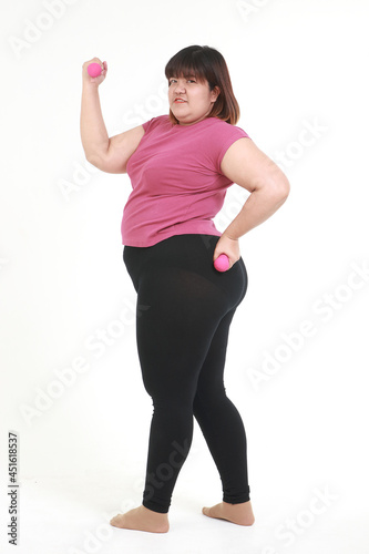 asian fat woman wear workout clothes holding pink dumbbells stand on a white background. health care concept, weight loss for good health