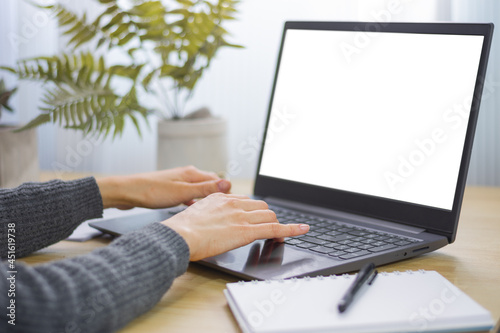 Mujer escribiendo en laptop.