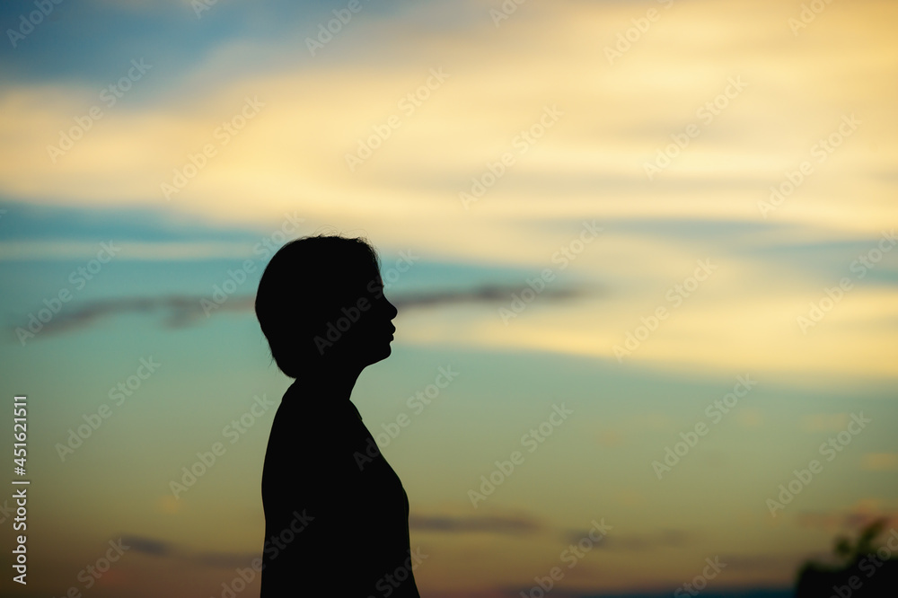 silhouette woman with sadness at sunset alone.