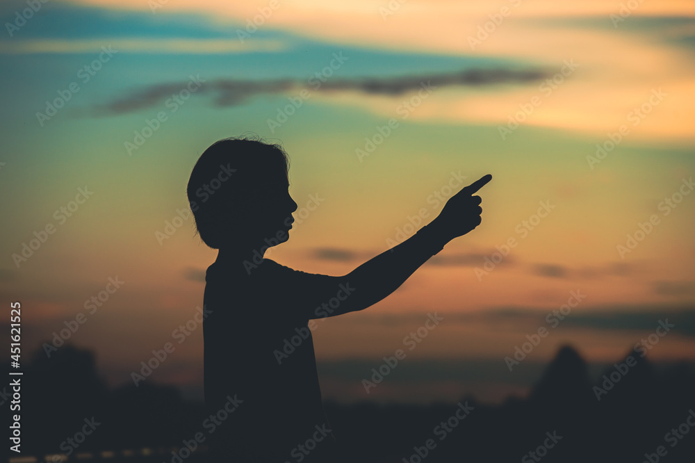 Fototapeta premium young woman pointing her hand aiming destination success at sunset.