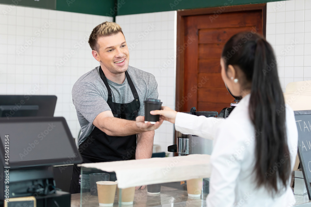 Fototapeta premium male barista giving a cup of coffee to customer in cafe or coffee shop